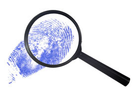 magnifying glass looking at thumbprint - identity theft