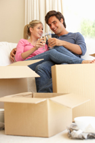 cohabiting couple unpacking after moving toasting with champagne