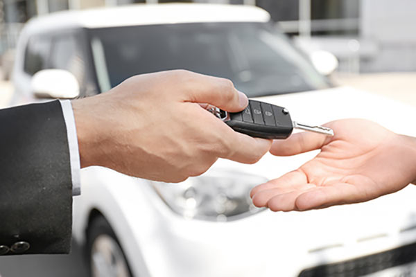 A person handing the keys to a car over to another person.