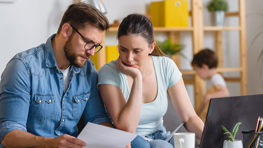 Two discouraged people looking at a piece of paper and trying to recover from tax ID theft.