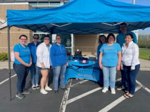 Diamond employees standing under a tent next to their info table.