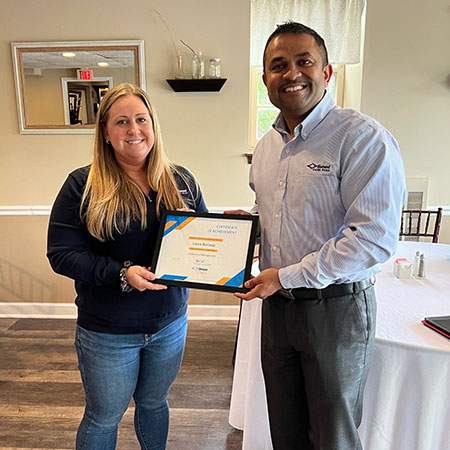 Rick Patel, handing Laura Buroojy her Certificate of Completion for Level One of the Essentials of Management program.