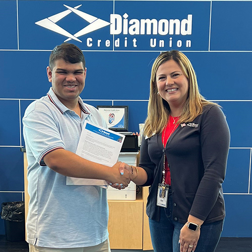 A Diamond Credit Union representative shakes hands with the Alfred Panfile Muhlenberg Scholarship Recipient.