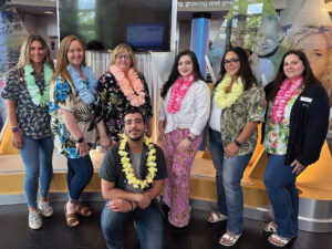 7 team members standing and kneeling in Hawaiian attire for a dress down theme day. internship program.