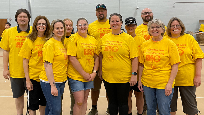 Eleven Diamond Credit Union volunteers are pictured at the United Way of Berks County's Big Cheese event. They are wearing mustard yellow t-shirts that say, "Doing gouda work in our community, Big Cheese 9."