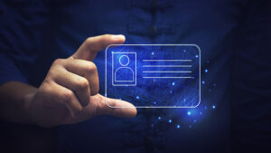 ID is required for a business account. Person's hand holding a holographic ID card signifying your digital identity and need for financial security.