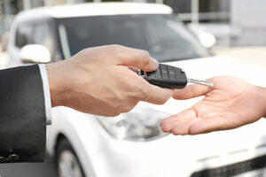 A person handing the keys to a car over to another person representing business vehicle loans.