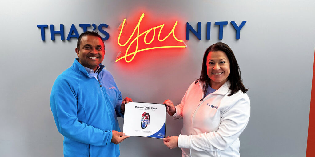 Diamond Credit Union's President/CEO, Rick Patel pictured with Diamond Credit Union's VP of Member Experience, Chelsea Fry, holding the 2026 People's Choice Award in front of Diamond's Younity wall in Pottstown, Pa.