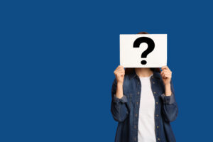 mystery shopper. woman standing holding a sign with a question mark in front of her face