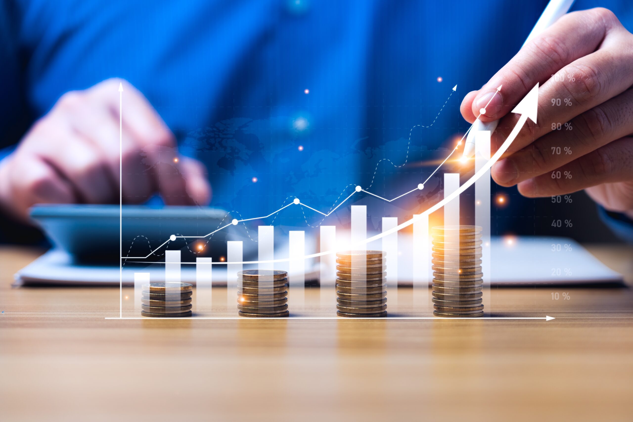 man using calculator while stacking coins to show growth for business growth accounts